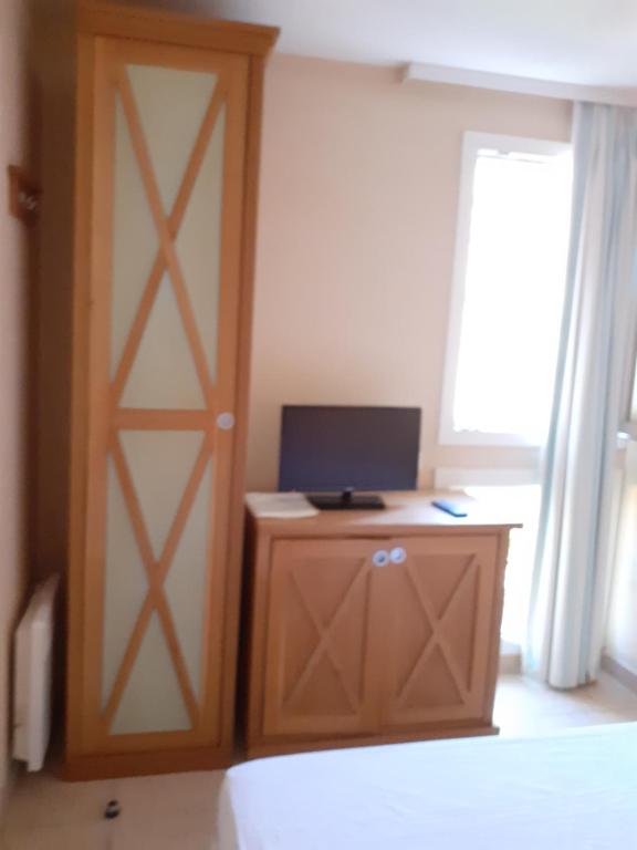 a room with a door and a computer on a desk at chez josette 300m de l ocean in Soulac-sur-Mer