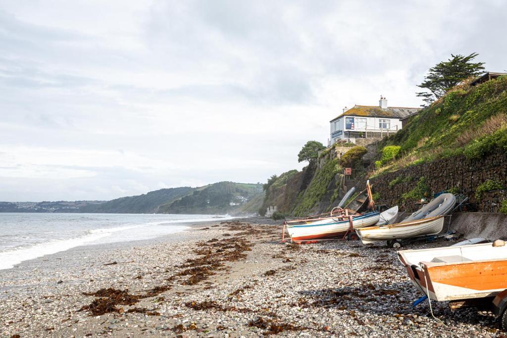 um grupo de barcos na costa de uma praia em Inn on the Shore em Downderry