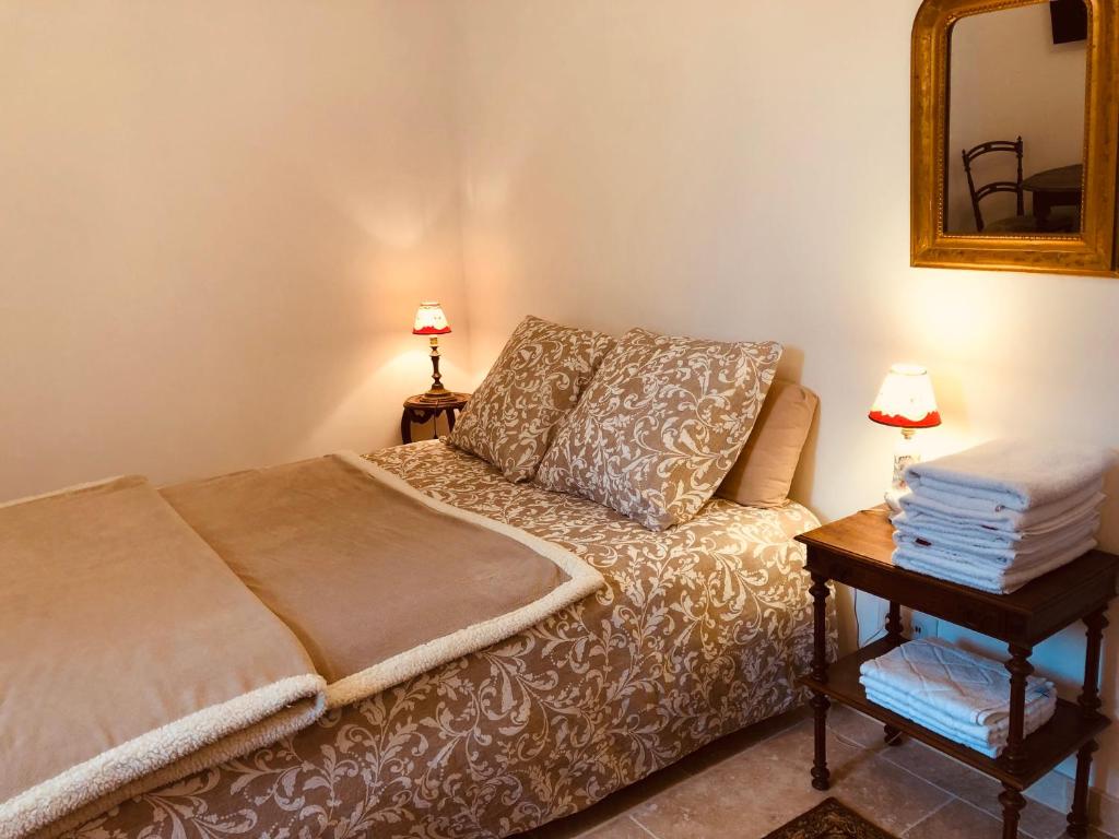um quarto com uma cama e uma mesa com um espelho em Chez Nelly : Escapade campagne Toulousaine em Bessières