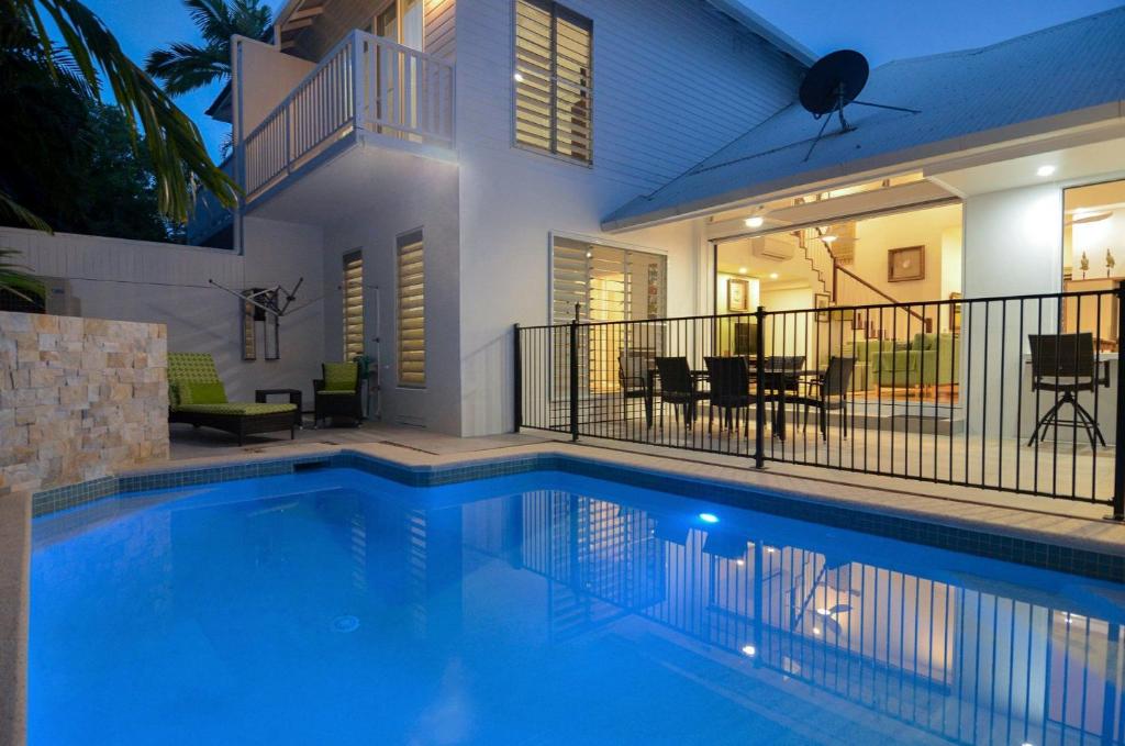 a swimming pool in front of a house at Beach Villa 5 in Port Douglas
