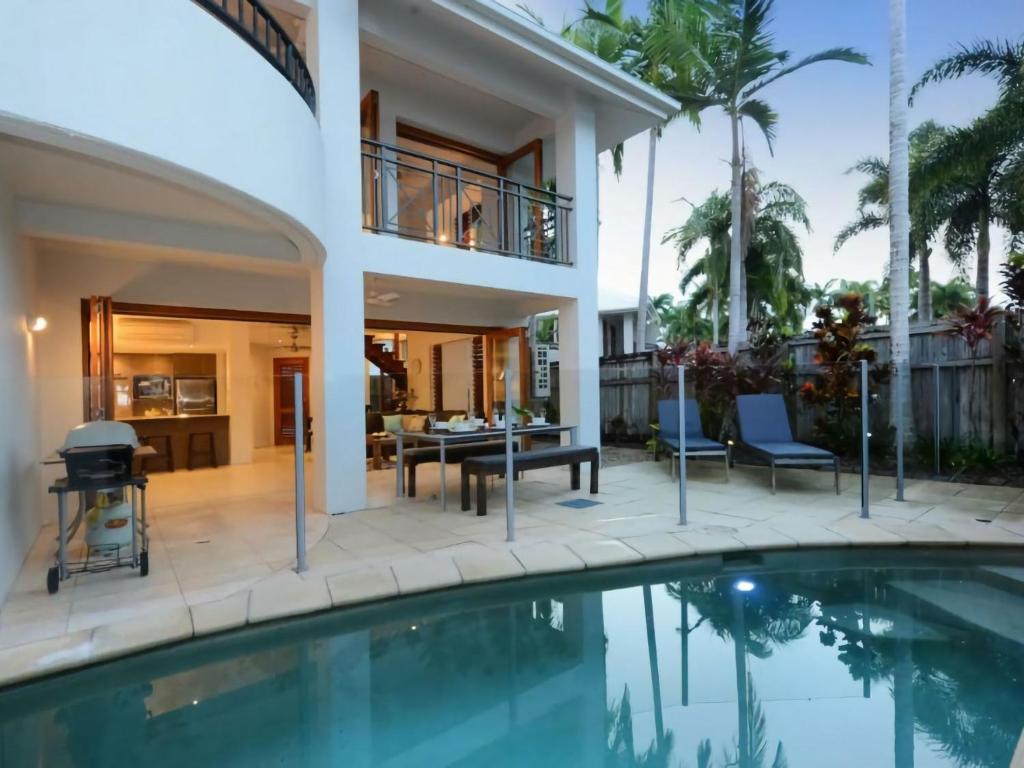 una casa con piscina frente a una casa en 7 Templemoon, en Port Douglas