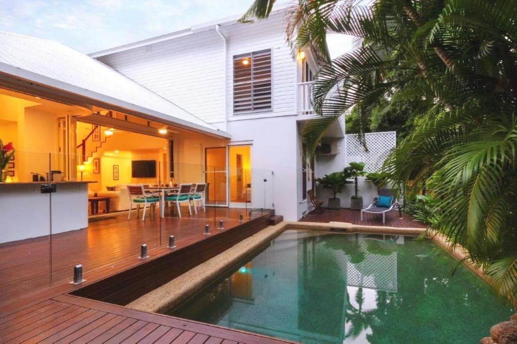 uma casa com piscina em frente a uma casa em Beach Villa 3 em Port Douglas