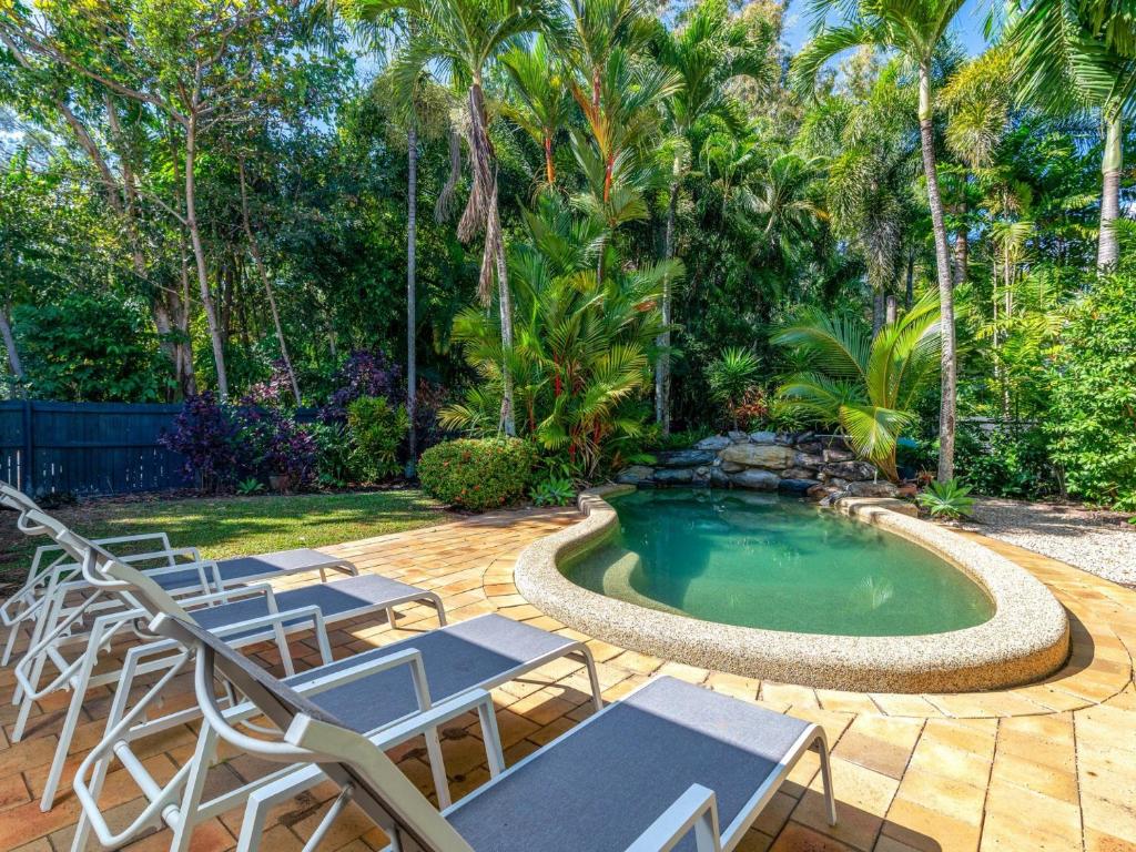 a patio with chairs and a swimming pool at Blue Sage in Port Douglas