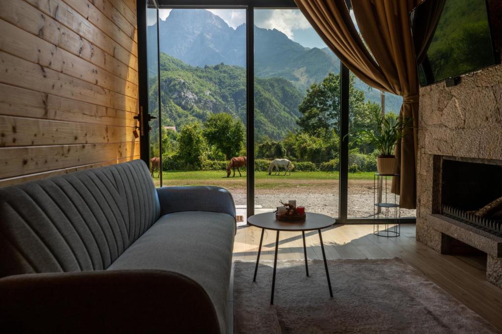 uma sala de estar com um sofá e uma lareira em Villa Ujëvara e vogël em Theth