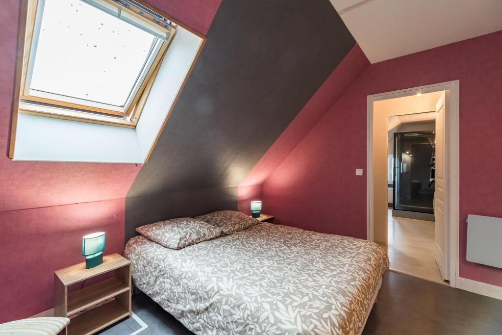 a bedroom with red walls and a bed with a window at Les Choucas - Maison pour 9 avec terrasse in Plouaret