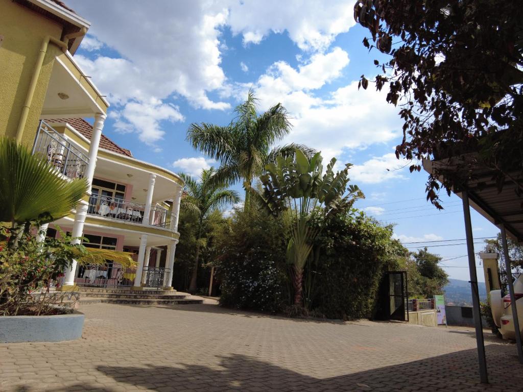 a house with a palm tree in front of it at DANA KIGALI HOTEL in Kigali
