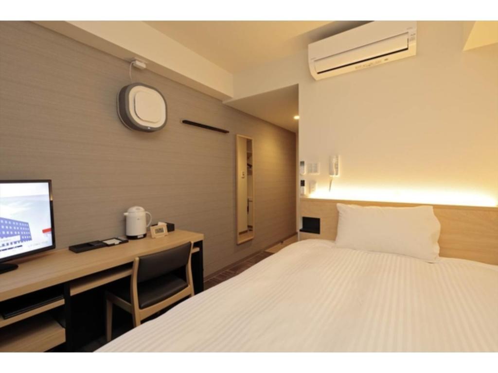 a bedroom with a bed and a desk and a tv at A&Bee HOTEL - Vacation STAY 35415v in Oita