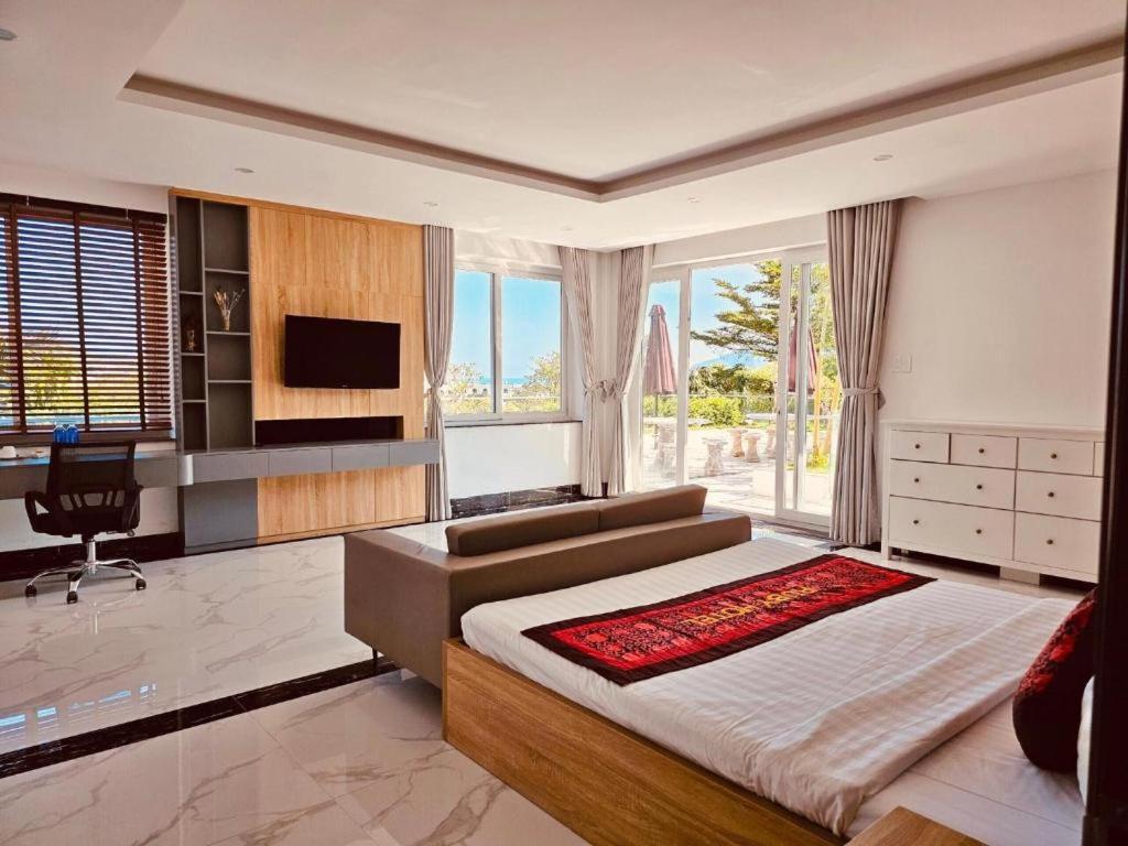 a bedroom with a bed and a desk and a television at RUBY 2 LUXURY VILLA by NEST GROUP in Nha Trang