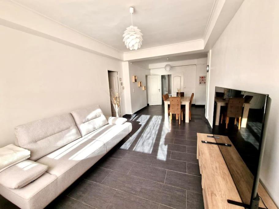 un salon avec un canapé blanc et une table dans l'établissement Appartement cosy : 3 chambres, à Marseille