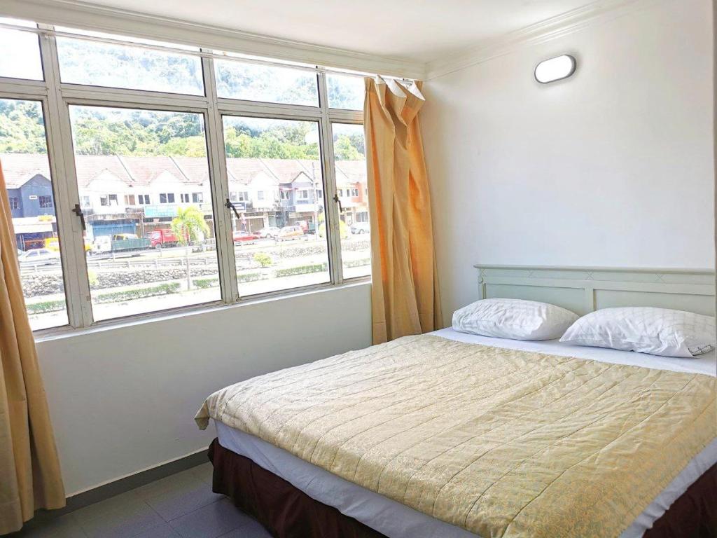 a bedroom with a bed and a large window at Vive Inn in Kuah
