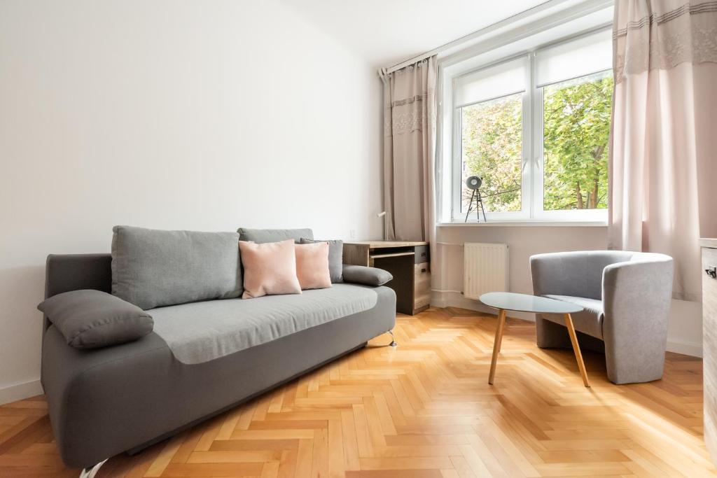 a living room with a couch and a table at Plac Zbawiciela 3-Bedroom Apartment in Warsaw