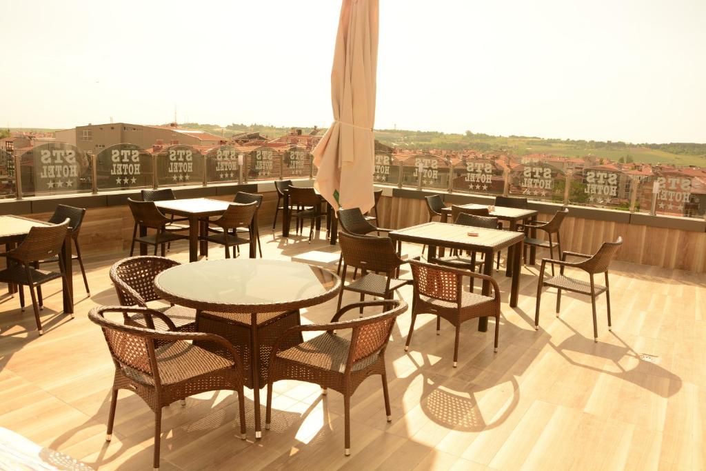 un patio con tavoli e sedie su un balcone di STS Hotel Luleburgaz a Lüleburgaz