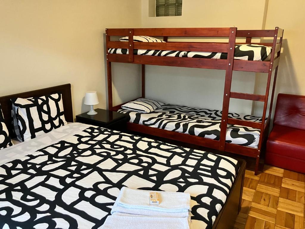 a bedroom with two bunk beds and a chair at MicroRent Rooms in Braga