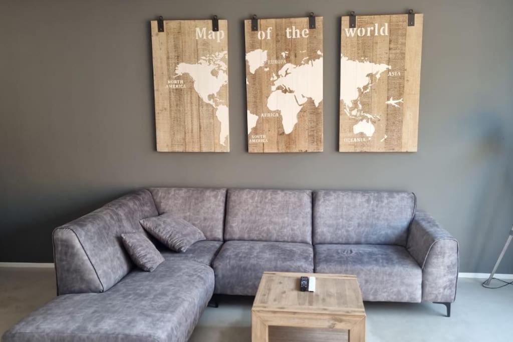 a living room with a couch and a map on the wall at Residence Gilze in Gilze