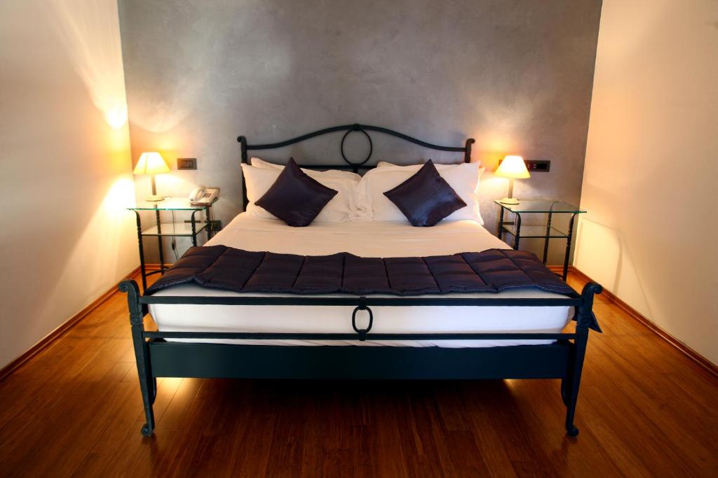 a bedroom with a large bed with two lamps at Hotel San Rocco in Muggia