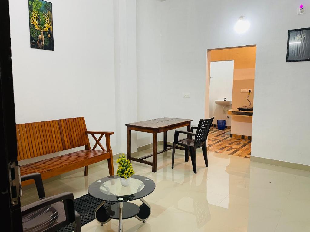sala de estar con sofá, mesa y sillas en Bethel inn, en Mananthavady