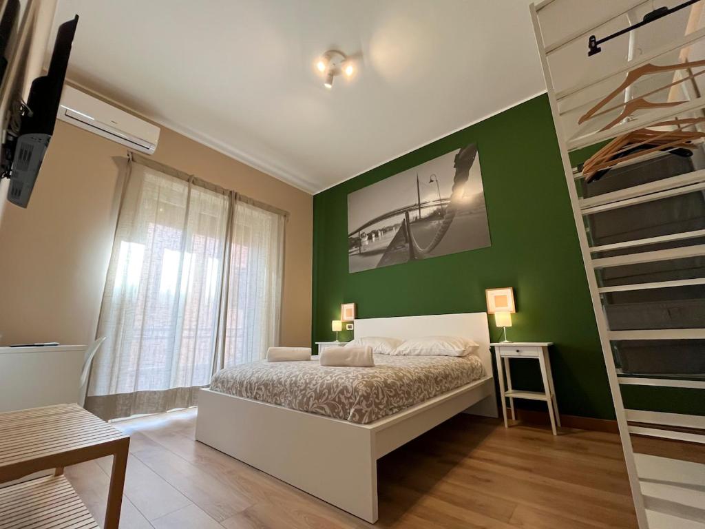 Un dormitorio con una cama y una pared verde. en Casa Emma, en Pescara