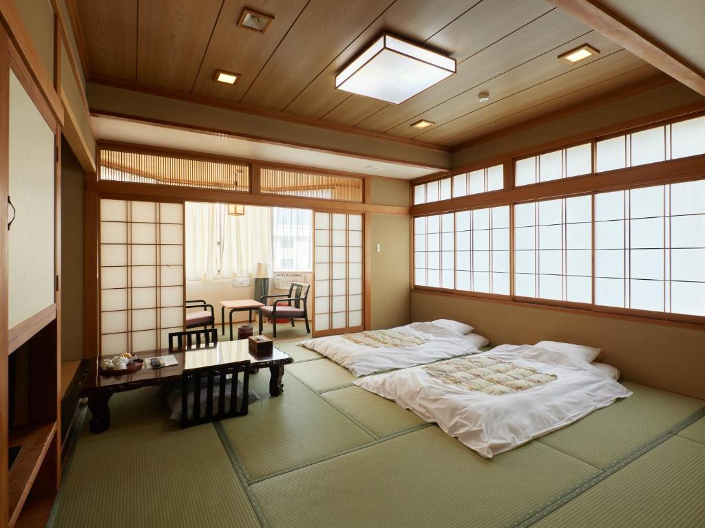 Postel nebo postele na pokoji v ubytování Sakura no Yakata Hotel