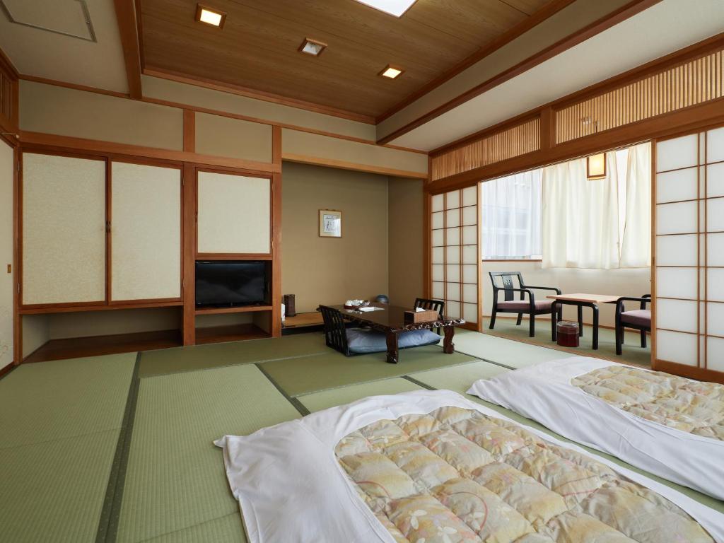 Postel nebo postele na pokoji v ubytování Sakura no Yakata Hotel