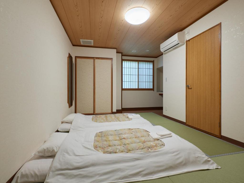 Postel nebo postele na pokoji v ubytování Sakura no Yakata Hotel