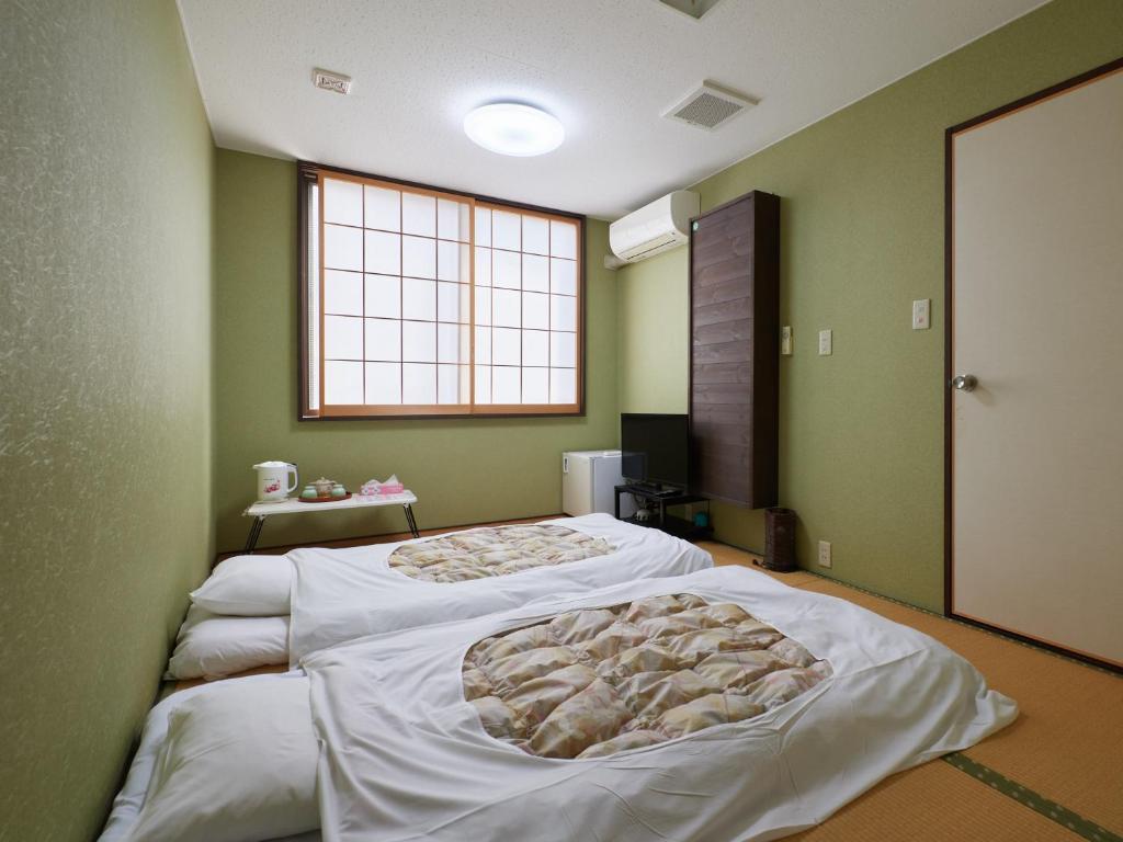 Postel nebo postele na pokoji v ubytování Sakura no Yakata Hotel
