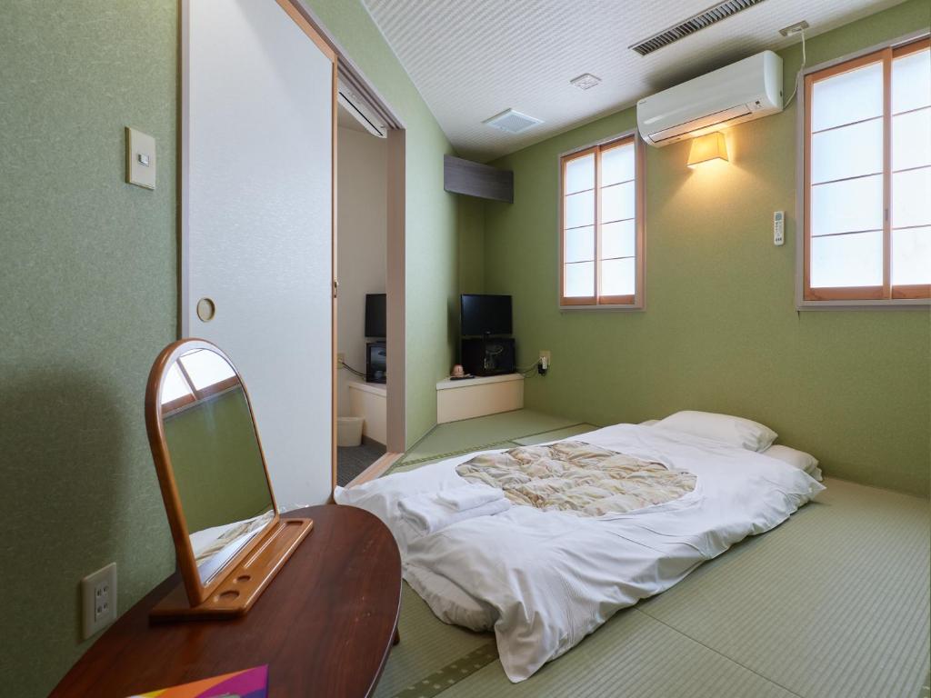 Postel nebo postele na pokoji v ubytování Sakura no Yakata Hotel