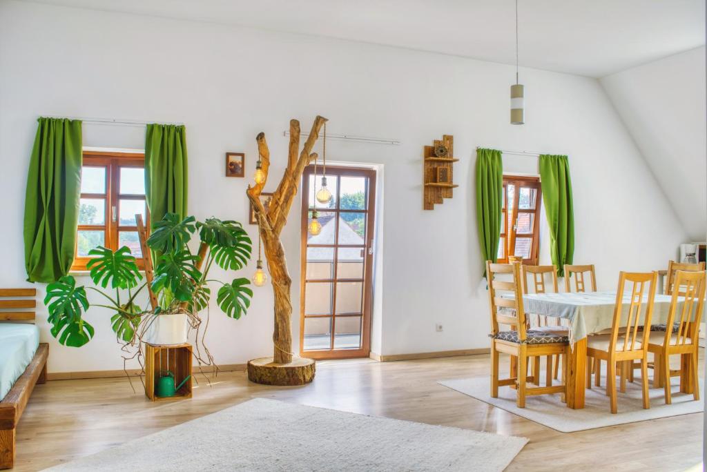 a living room with a table and a tree at Luxus Apartment! Küche, Balkon, Netflix, Parkplatz - 8 Personen in Ilmmünster