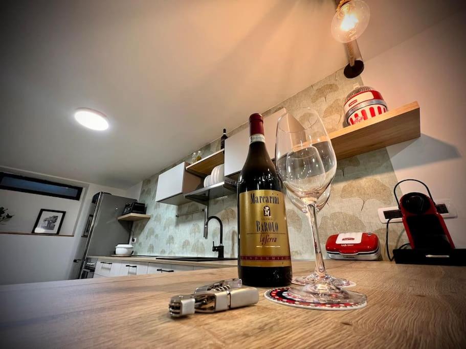 una botella de vino y una copa en la encimera de la cocina en La Perla en Monza
