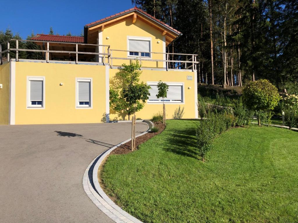 a yellow house with a driveway in front of it at Residence JORADO in Manning