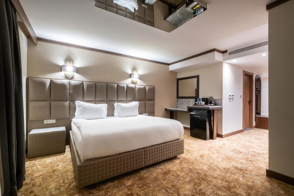 a hotel room with a large bed and a desk at Park Dedeman Kızılay Ankara in Ankara