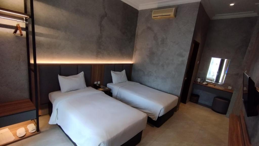 Postel nebo postele na pokoji v ubytování The Grand Palace Hotel Malang