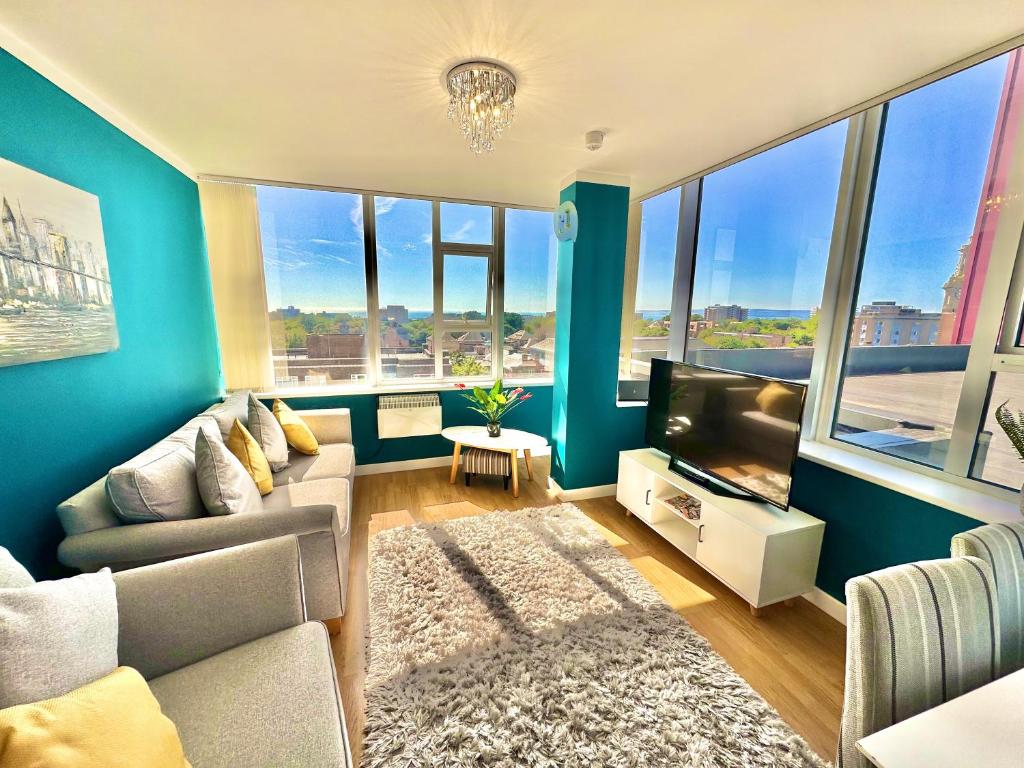 a living room with a couch and a tv at Gorgeous Sea View Two Bed Apartment - Close to Beach with Free Parking in Bournemouth