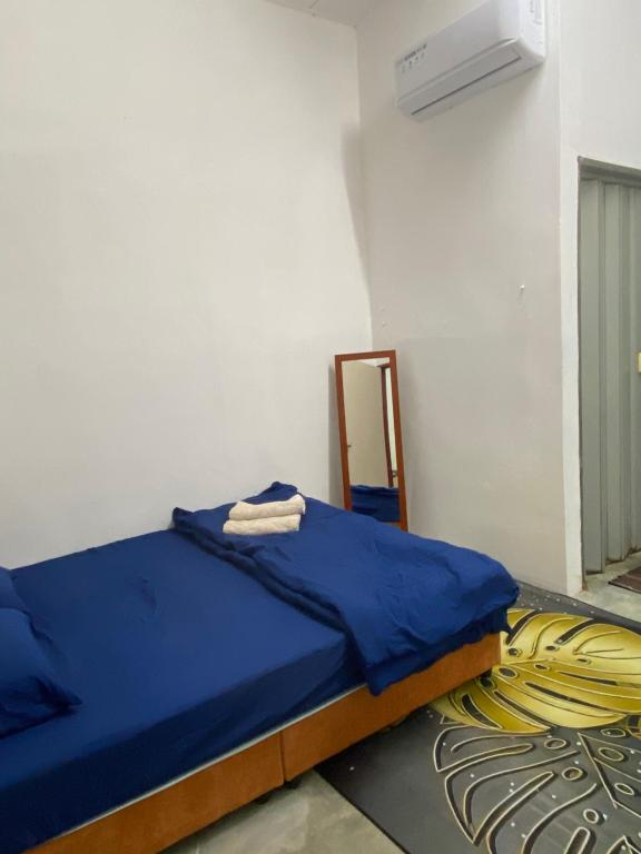 um quarto com uma cama com lençóis azuis e uma ventoinha em Cik Misi Homestay (2) em Sik