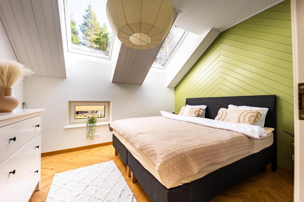 ein Schlafzimmer mit grünen und weißen Wänden und einem Bett in der Unterkunft Dirhami Pool Villa in Dirhami