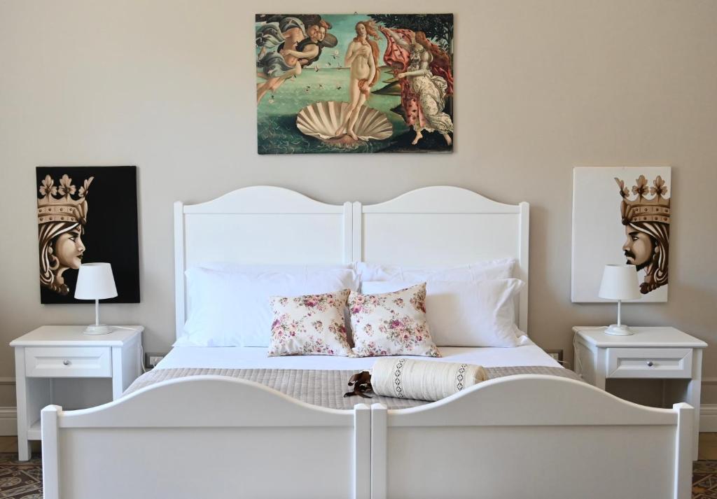 a bedroom with a white bed with two night stands at Civico 10 Deluxe Room in Licata