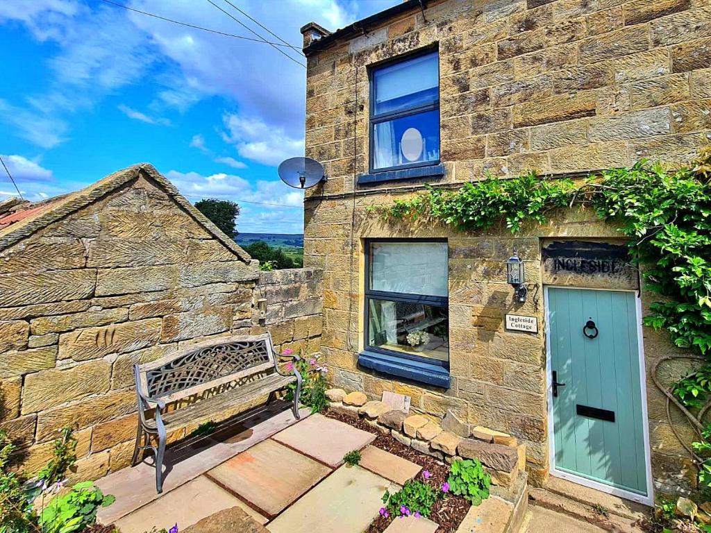 a brick building with a blue door and a bench at Finest Retreats - Ingleside Cottage in Whitby