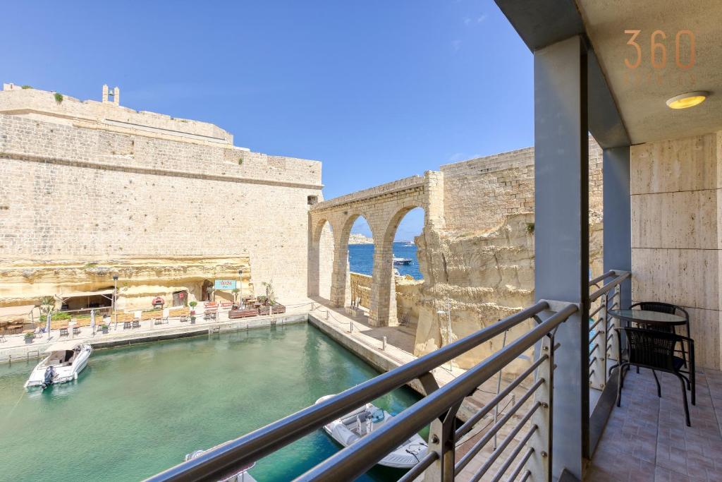 einen Balkon eines Gebäudes mit einem Pool in der Unterkunft Beautiful, spacious 3BR home with beautiful views by 360 Estates in Vittoriosa