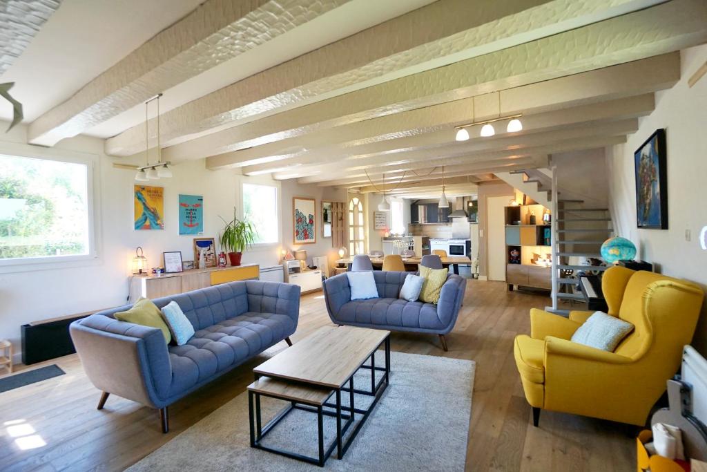 a living room with blue couches and yellow chairs at Kêr Melen in Concarneau