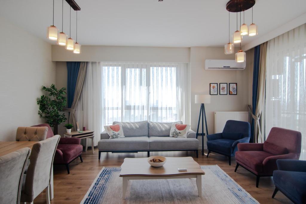 sala de estar con sofá, sillas y mesa en Charming 3bdr Apartment For A Memorable Stay, en Basaksehir