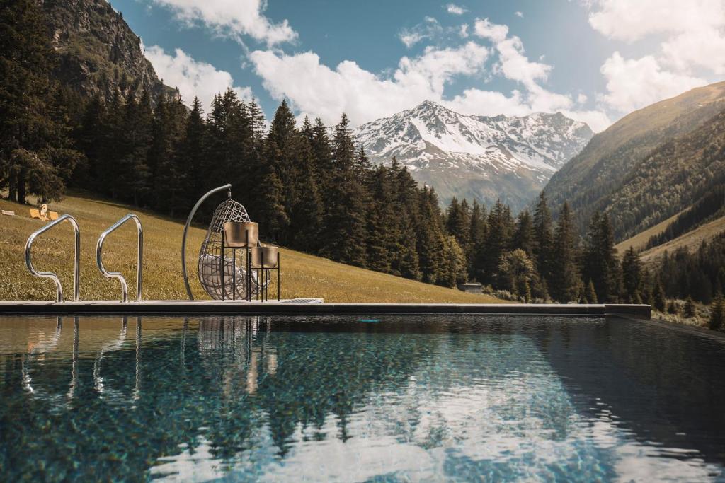 a swimming pool with mountains in the background at Alpine Resort Sportalm in Sankt Leonhard im Pitztal