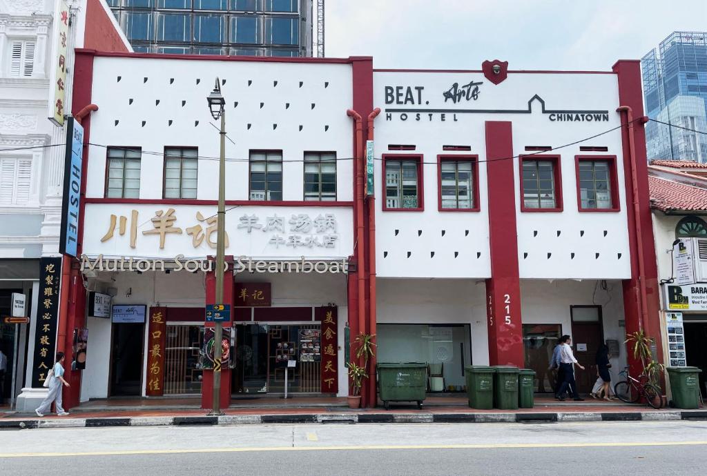 un edificio blanco y rojo en una calle de la ciudad en BEAT Arts Hostel at Chinatown, en Singapur