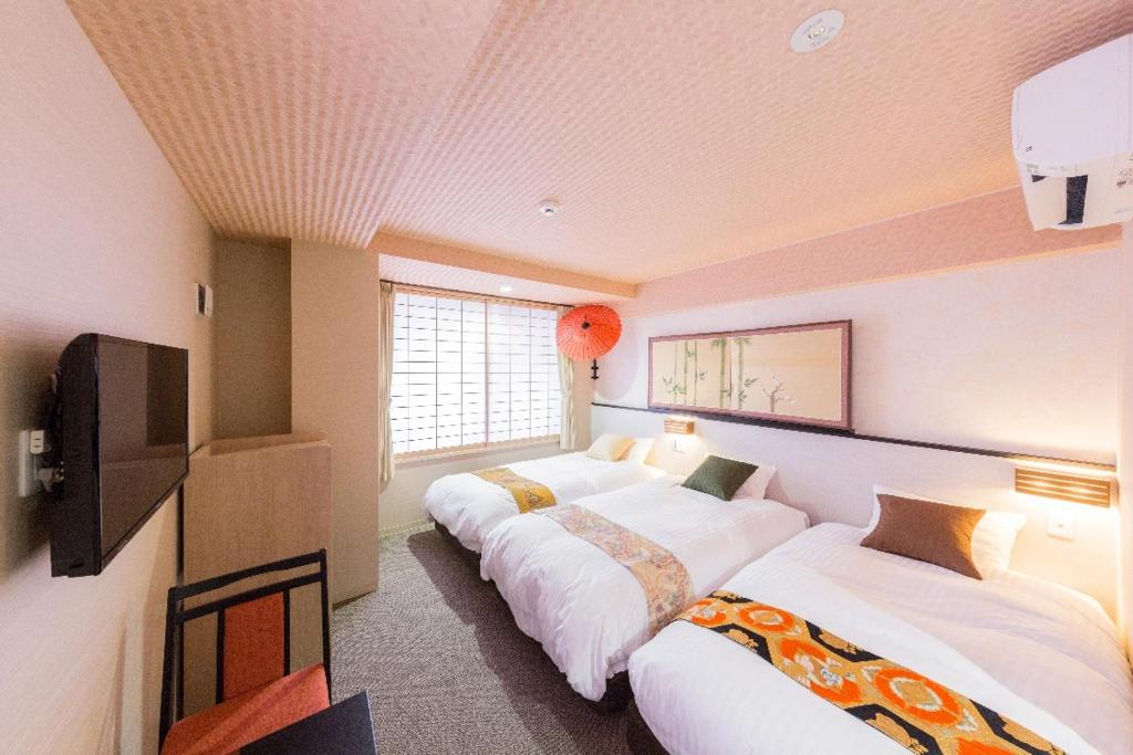 a room with two beds and a television in it at Kyoto Inn Gion The Second in Kyoto