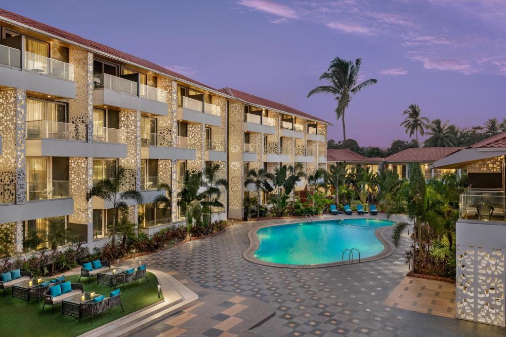 an exterior view of a hotel with a swimming pool at Hyatt Place Goa Candolim in Candolim