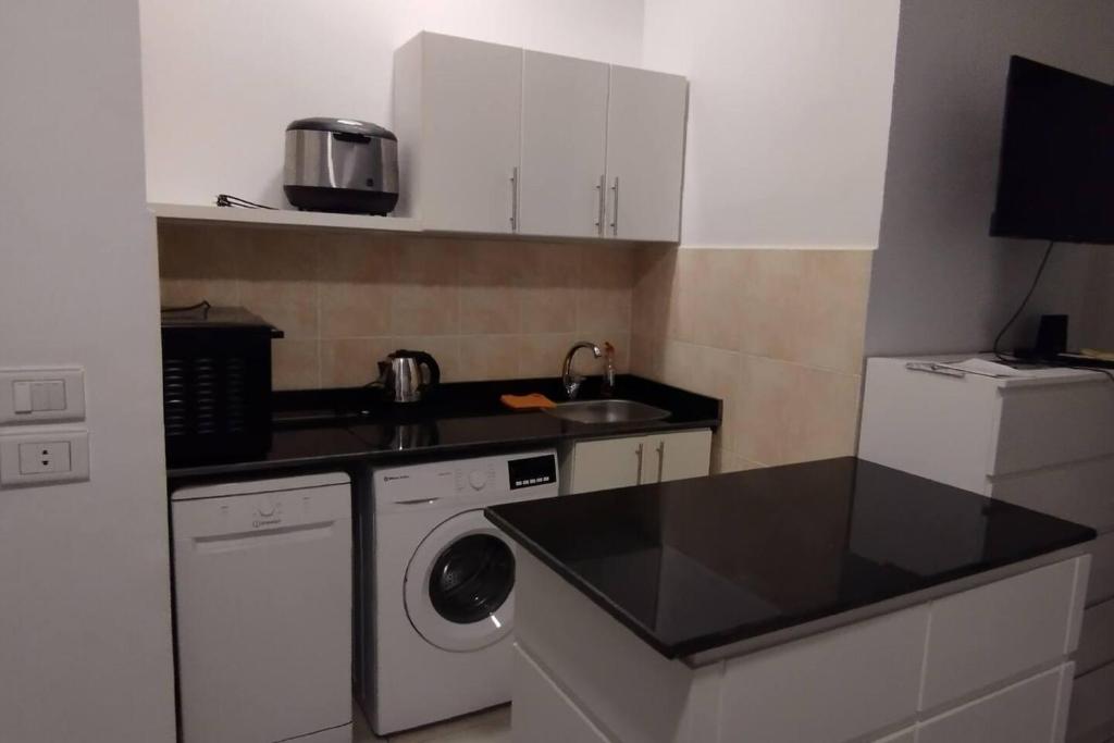 a kitchen with a sink and a washing machine at 1-Bed property in Makadi Heights in Hurghada