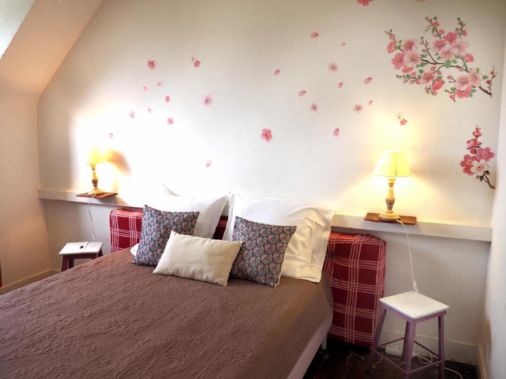 a bedroom with a bed with flowers on the wall at Les Gîtes du Couvent Alternatif in Camlez