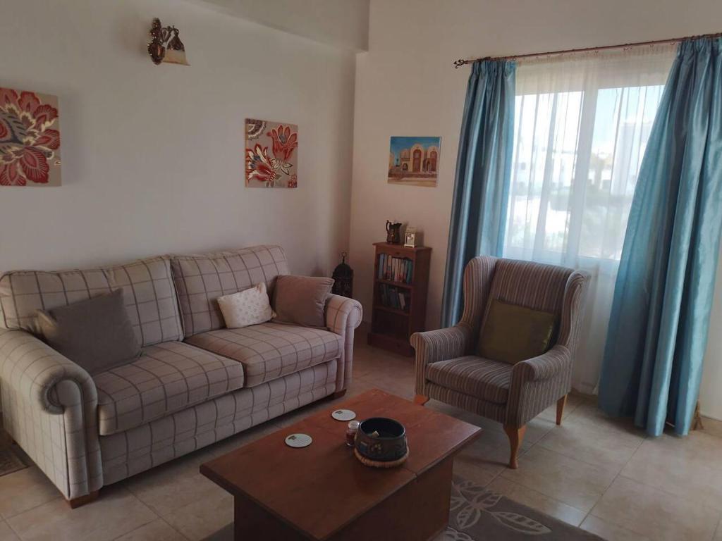 a living room with a couch and two chairs at British style in Makadi Heights in Hurghada