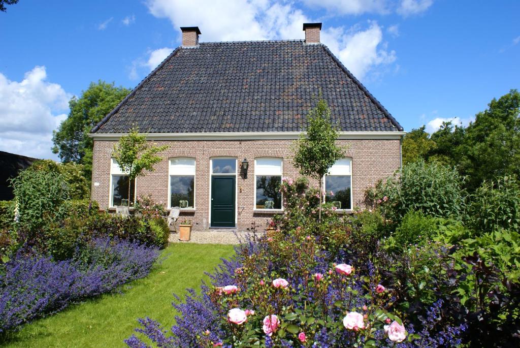 a house with a garden with flowers in front of it at Vakantiewoning Opa's Huisje in Ruinerwold