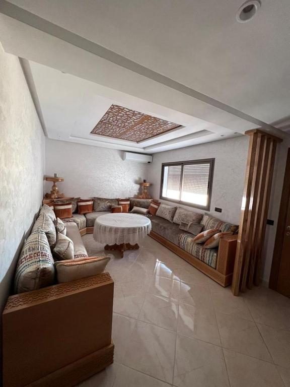 uma sala de estar com um sofá e uma mesa em Appartement la Ville Haute em Kenitra