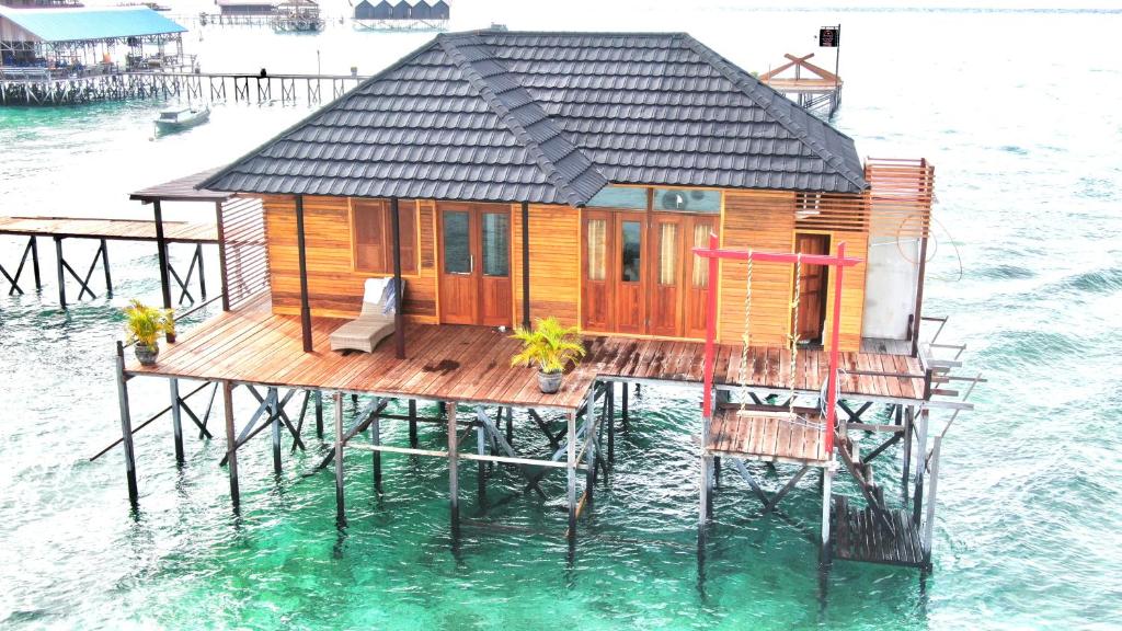 ein Haus auf einem Pier im Wasser in der Unterkunft Derawan Fisheries Cottage in Derawan Islands