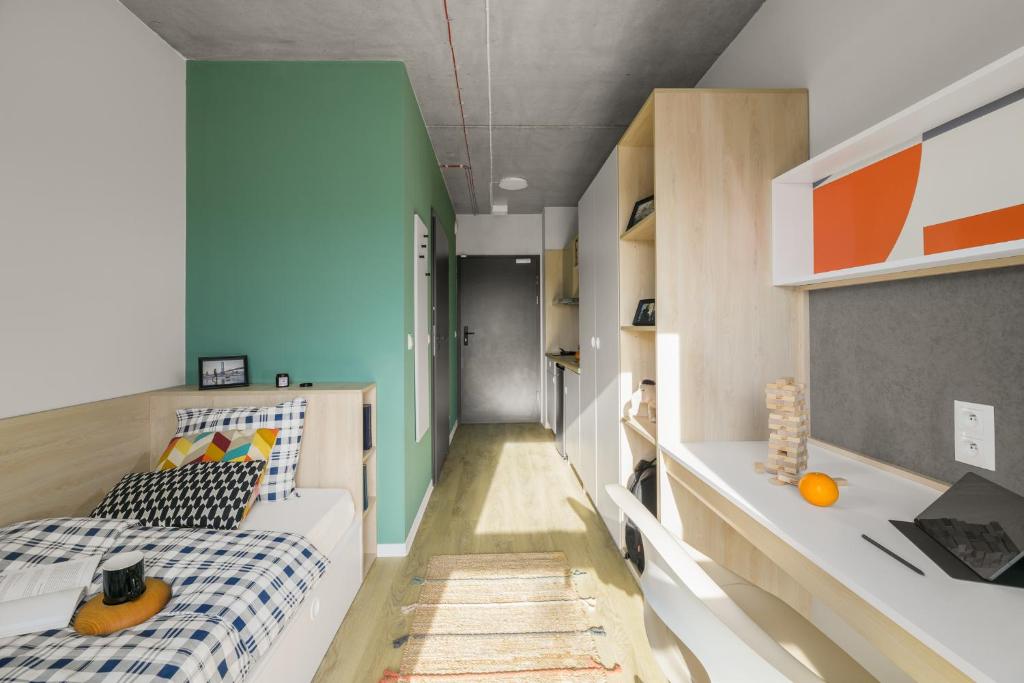 um pequeno quarto com uma cama e uma secretária em Apartamenty Depot Wróblewskiego em Lódź